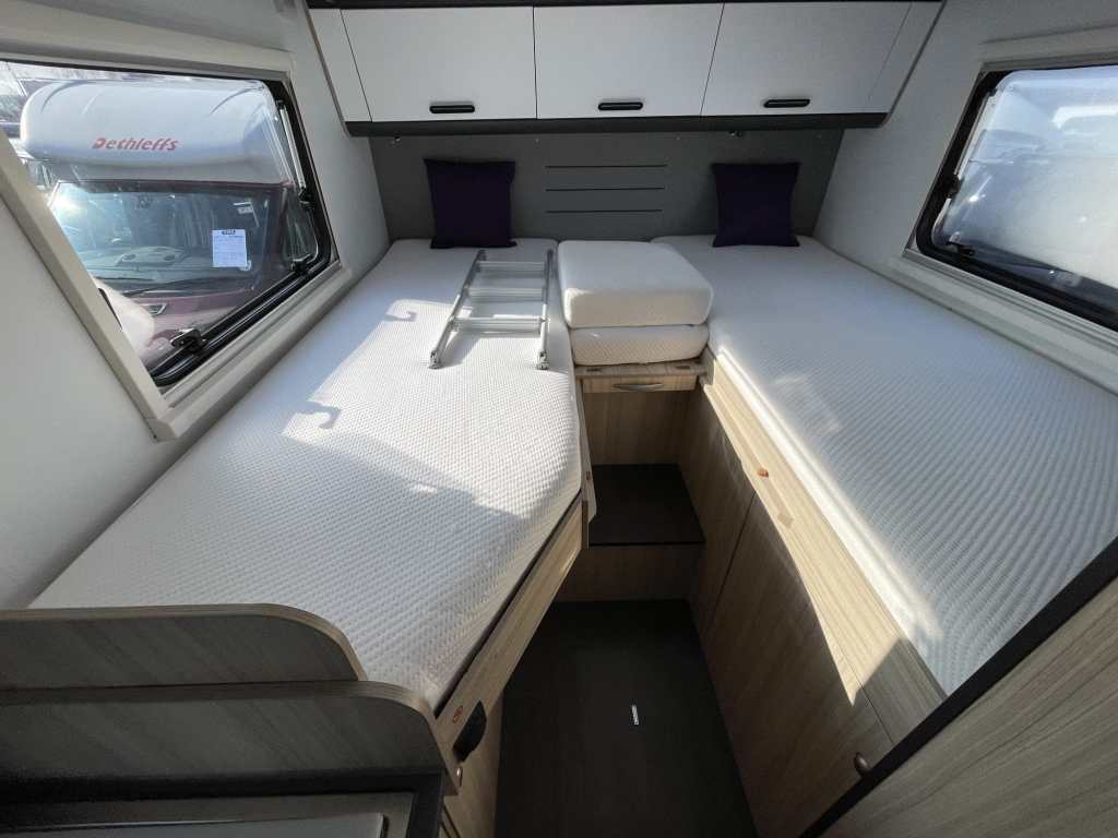 Adria motorhome rear fixed bed that pulls out from singles into a larger double with the infills